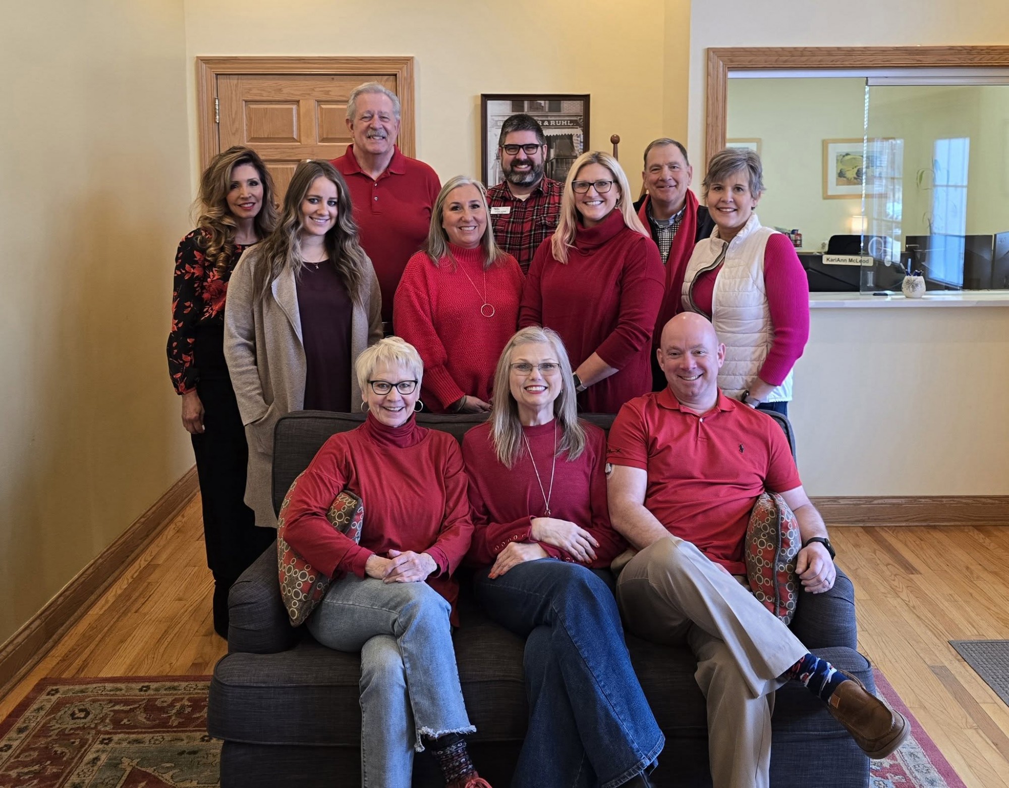 person in red sweater holding babys hand